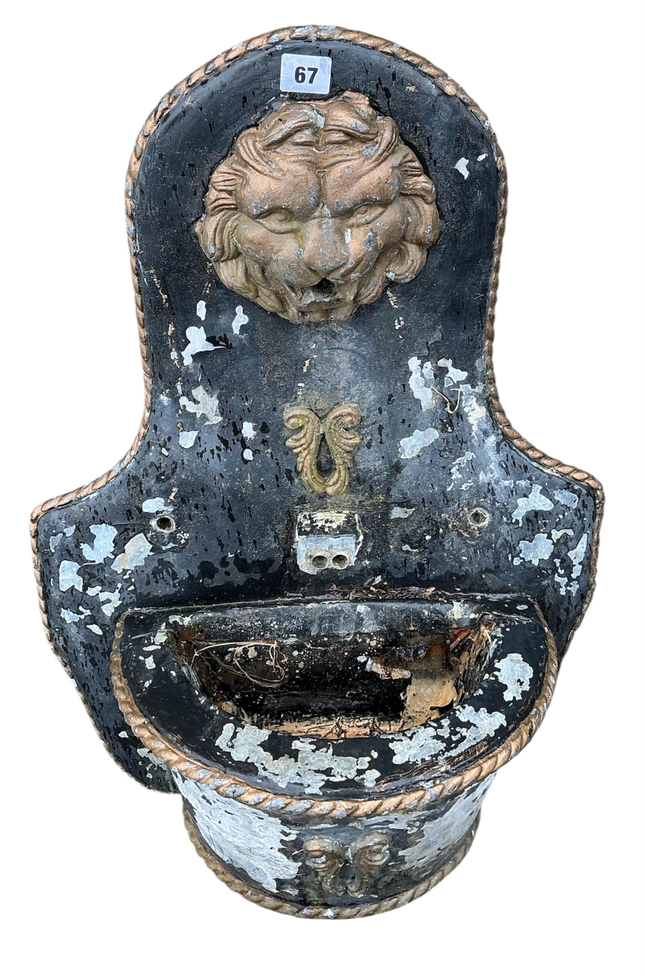 A reconstituted stone recumbent lion and ram garden ornament, length 60cm, together with a painted composition lion mask wall fountain